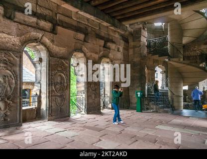 Ein Besucher macht Fotos im Inneren der berühmten Porta Nigra, einem großen römischen Stadttor in Trier, Deutschland. Im Mittelalter wurde es in zwei verwandelt... Stockfoto