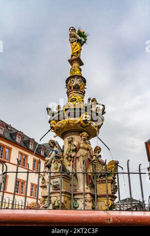 Nahaufnahme des Brunnens Petrusbrunnen auf dem zentralen Platz namens Hauptmarkt an einem bewölkten Tag in Trier, Deutschland. Oben auf der Brunnensäule... Stockfoto