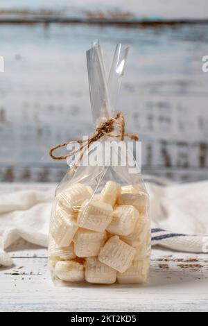 Milchbonbons. Süßigkeiten auf weißem Holzhintergrund. Schließen Stockfoto