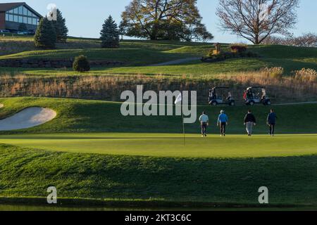 Vierer, die nach dem Golfspielen das 18.-Loch-Loch verlassen, am späten Nachmittag in Pennsylvania, USA Stockfoto