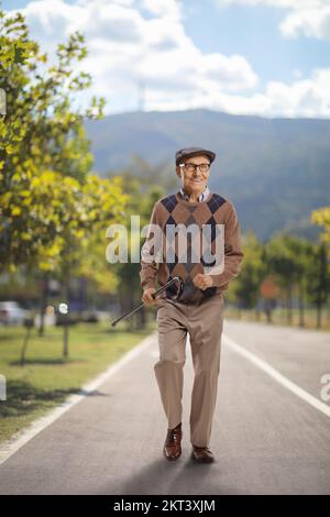 Glücklicher alter Mann, der auf einer Fußgängerbahn läuft Stockfoto