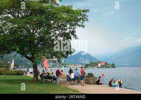 Stresa Lago Maggiore, im Sommer sehen Sie die Menschen, die auf der Passeggiata Lungolago am Ufer von Stresa spazieren, mit Isola Bella im See, Italien Stockfoto