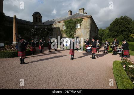 Dumfries House, Cumnock, Scotland UK, Ayr Pipe Band spielen vor dem Haus. Sie spielten für Gäste, die im Haus unterhalten wurden. Dumfries House ist ein Palladianisches Landhaus in Ayrshire, Schottland. Es befindet sich auf einem großen Anwesen, rund 3 Meilen westlich von Cumnock. Der Brunnen, auch bekannt als Mahfouz-Brunnen. Eine Seuche in der Nähe sagt: " Möglich durch die Großzügigkeit VON MAHFOUZ Marei Murbank bin Mahfouz. Der Brunnen wurde offiziell eröffnet von H. R.H. dem Prinzen Charles, Herzog von Rothesay am 21. Oktober 2014. Stockfoto