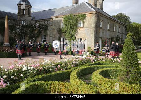 Dumfries House, Cumnock, Scotland UK, Ayr Pipe Band spielen vor dem Haus. Sie spielten für Gäste, die im Haus unterhalten wurden. Dumfries House ist ein Palladianisches Landhaus in Ayrshire, Schottland. Es befindet sich auf einem großen Anwesen, rund 3 Meilen westlich von Cumnock. Der Brunnen, auch bekannt als Mahfouz-Brunnen. Eine Seuche in der Nähe sagt: " Möglich durch die Großzügigkeit VON MAHFOUZ Marei Murbank bin Mahfouz. Der Brunnen wurde offiziell eröffnet von H. R.H. dem Prinzen Charles, Herzog von Rothesay am 21. Oktober 2014. Stockfoto