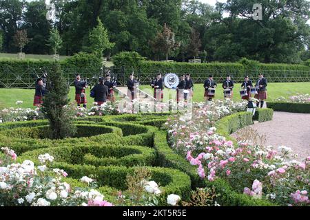 Dumfries House, Cumnock, Scotland UK, Ayr Pipe Band spielen vor dem Haus. Sie spielten für Gäste, die im Haus unterhalten wurden. Dumfries House ist ein Palladianisches Landhaus in Ayrshire, Schottland. Es befindet sich auf einem großen Anwesen, rund 3 Meilen westlich von Cumnock. Der Brunnen, auch bekannt als Mahfouz-Brunnen. Eine Seuche in der Nähe sagt: " Möglich durch die Großzügigkeit VON MAHFOUZ Marei Murbank bin Mahfouz. Der Brunnen wurde offiziell eröffnet von H. R.H. dem Prinzen Charles, Herzog von Rothesay am 21. Oktober 2014. Stockfoto