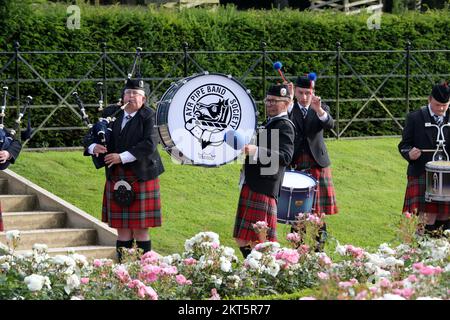 Dumfries House, Cumnock, Scotland UK, Ayr Pipe Band spielen vor dem Haus. Sie spielten für Gäste, die im Haus unterhalten wurden. Dumfries House ist ein Palladianisches Landhaus in Ayrshire, Schottland. Es befindet sich auf einem großen Anwesen, rund 3 Meilen westlich von Cumnock. Der Brunnen, auch bekannt als Mahfouz-Brunnen. Eine Seuche in der Nähe sagt: " Möglich durch die Großzügigkeit VON MAHFOUZ Marei Murbank bin Mahfouz. Der Brunnen wurde offiziell eröffnet von H. R.H. dem Prinzen Charles, Herzog von Rothesay am 21. Oktober 2014. Stockfoto