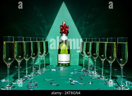 Silhouette aus festlichem Baum, Flasche Champagner mit Gläsern auf grünem Hintergrund. Merry Christmas und Happy New Year Concept Stockfoto