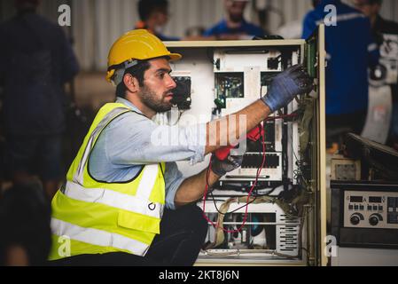 Elektroingenieur-Prüfgerät zur Messung von Spannung und Strom von Stromleitungen in der Schaltschranksteuerung für die industrielle Produktion. Stockfoto