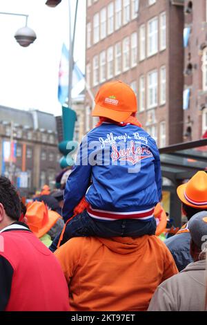 Junge, die die königliche Balkonszene beobachtet, Amsterdam, Niederlande, 30. April 2013. Stockfoto