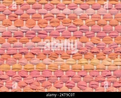 Nahaufnahme handgewebter Teppiche in warmen und leuchtenden Pastelltönen, einfarbig. Stockfoto