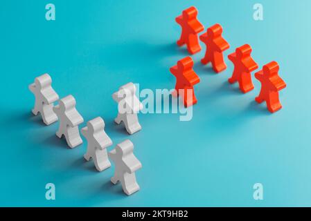 Zwei Gruppen von Holzfiguren stehen nebeneinander Stockfoto