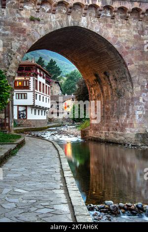 Mittelalterliches Dorf Potes mit hängenden Häusern und dem Fluss Deva, Kantabrien, Spanien. Stockfoto