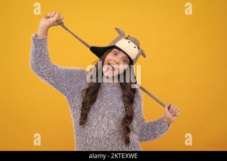 Mode glücklich junge Frau in gestrickten Hut und Pullover mit Spaß über bunten blauen Hintergrund. Aufgeregt Teenager Mädchen. Stockfoto