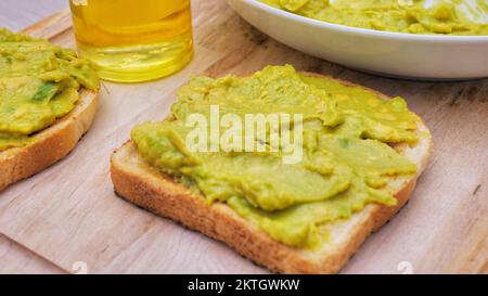 Avocado Toast auf Vollkorn sandwich Brot. Tabelle Ansicht von oben. Guacamole Toasts. Konzept der gesunden Ernährung, Diäten, vegan vegetarische Kost Stockfoto