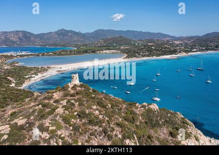 Blick aus der Vogelperspektive auf die Spiaggia di Porto Giunco, eine wunderschöne Bucht in der Nähe eines Wachturms aus dem 17.. Jahrhundert, den Aragonesischen Turm von Porto Giunco in Sardinien, Italien Stockfoto