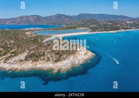 Blick aus der Vogelperspektive auf die Spiaggia di Porto Giunco, eine wunderschöne Bucht in der Nähe eines Wachturms aus dem 17.. Jahrhundert, den Aragonesischen Turm von Porto Giunco in Sardinien, Italien Stockfoto