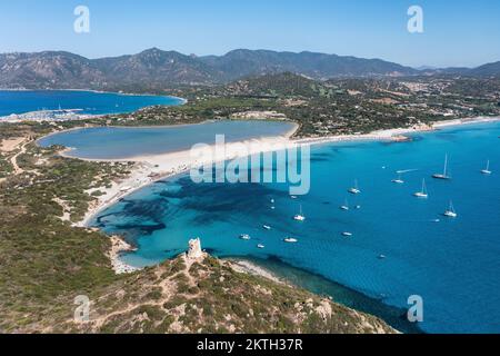 Blick aus der Vogelperspektive auf die Spiaggia di Porto Giunco, eine wunderschöne Bucht in der Nähe eines Wachturms aus dem 17.. Jahrhundert, den Aragonesischen Turm von Porto Giunco in Sardinien, Italien Stockfoto