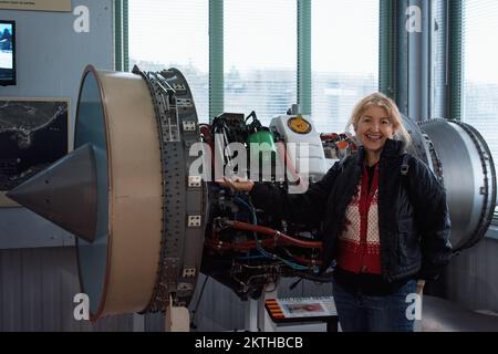 Im Aviation Museum of New Hampshire steht ein Besucher vor einem General Electric TF38 Jet-Triebwerk. Londonderry, New Hampshire. Stockfoto