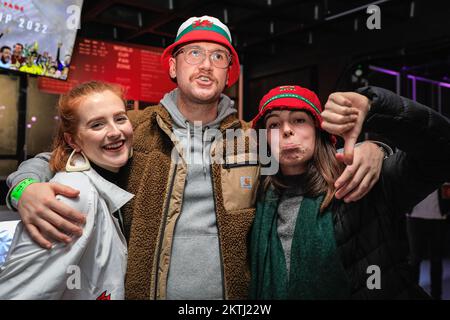 London, Großbritannien. 29.. November 2022. Manche walisische Fans nehmen den Verlust mit Humor auf. Englische Fans feiern die drei Tore und gewinnen, während Wales-Fans enttäuscht sind, aber die gute Atmosphäre am Veranstaltungsort genießen. Fans von England und Wales sehen sich das Fußballspiel England gegen Wales im 4TheFans Fan Park im Dalston Roof Park an. Die Analyse von Geplänkel und Spielen beim Screening erfolgt durch die Fußballlegende Steve Hodge. Kredit: Imageplotter/Alamy Live News Stockfoto