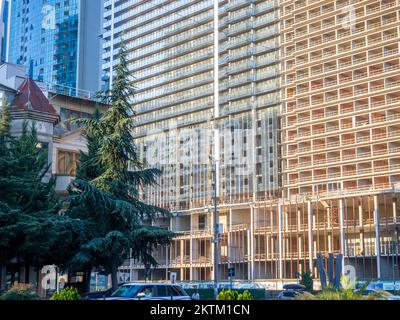 Viele Fenster. Bogen am Eingang. Hohe Gebäude. Modernes Apartmentgebäude. Stadtzentrum. Batumi. Architektonisches Ensemble Stockfoto