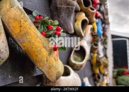 Komposition an der Wand aus traditionellen holländischen Holzschuhen - Klompen (Clogs), dekoriert mit Blumen, Schließung, Niederlande Stockfoto