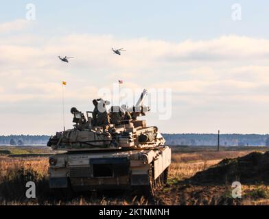 Polnische Soldaten der NATO-Kampfgruppe mit verstärkter Präsenz, die 3.. Bataillon, 8.. Kavallerie-Regiment, 3.. Bewaffnete Brigaden-Kampftruppe, 1.. Kavallerie-Division (3-1 ABCT), operativ kontrolliert von der 1.. Infanterie-Division (1 ID), Beobachten Sie, wie zwei polnische Mi-24 Hubschrauber während der Live-Feuerübung Bull Run in Bemowo Piskie, Polen, am 17. November 2022 überfliegen. Der 3-1. ABCT ist unter anderem dem 1. ID zugeteilt und arbeitet stolz mit NATO-Verbündeten und regionalen Sicherheitspartnern zusammen, um Kampfkräfte für das V Corps, Amerikas vorwärtsgebrachtes Korps in Europa, bereitzustellen. (USA Army National Stockfoto