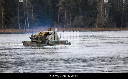 Die polnischen Soldaten, die der 20.. Brigade zugeteilt wurden, nutzen einen Army Medium Amphibious Transport, um ein UK zu transportieren Royal Lancers, Prince of Wales Truppe 2A Mobilitätswaffen-montiertes Einbausatz Fahrzeug über einem See bei amphibischen Angriffen während der Bull Run Trainingsübung in Bemowo Piskie, Polen, 24. November 2022. Die mechanisierte Brigade aus dem Jahr 20. arbeitet stolz mit der 1.. Infanteriedivision, NATO-Verbündeten und regionalen Sicherheitspartnern zusammen, um dem V-Corps unter Amerikas vorwärtsgerichtetem Korps in Europa kämpferische Kräfte zur Verfügung zu stellen. (USA Foto der Nationalgarde der Armee Stockfoto