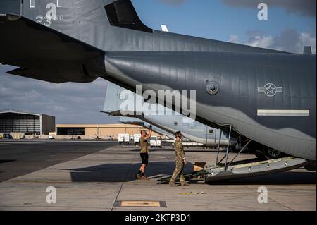 USA Die dem 81.. Expeditionary Rescue Squadron (ERQS) zugeteilten Flieger beladen ein Fahrzeug auf einen HC-130J Combat King II in Camp Lemonnier, Dschibuti, am 16. Oktober 2022. Der ERQS 81. ist eine schnell einsetzbare Such- und Rettungskraft, die Personal und/oder Ausrüstung im Rahmen der kombinierten Gemeinsamen Task Force (im Zuständigkeitsgebiet Horn von Afrika) bei Tag und Nacht taktisch auftanken, in die Luft absetzen und in die Luft absetzen kann, um die Bergung des Kampfpersonals zu unterstützen. (USA Air Force Photo von Staff Sgt. Devin M. Rumbaugh) Stockfoto