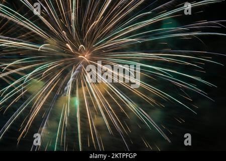 Grünes und blaues Feuerwerk vor schwarzem Himmel bei Nacht. Stockfoto
