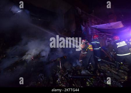 Peshawar, Khyber Pakhtunkhwa, Pakistan. 29.. November 2022. Pakistanische Feuerwehrmänner versuchen, einen Brand in einem Elektronikladen zu löschen, der aufgrund eines Stromkurzschlusses in Peshawar ausbrach. (Kreditbild: © Hussain Ali/Pacific Press via ZUMA Press Wire) Stockfoto