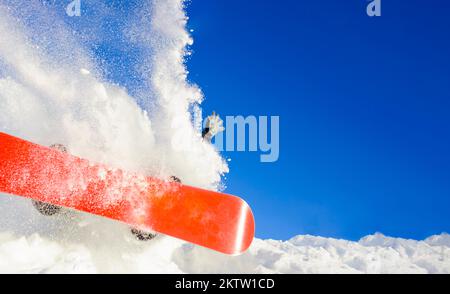 Junger Mann auf dem Snowboard, der im Winter über den Hang springt Stockfoto