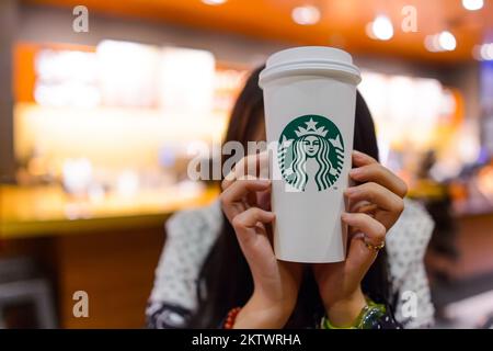 SHENZHEN, CHINA - 31. JANUAR 2015: Starbucks Gast hält eine Tasse Kaffee. Starbucks Corporation ist ein amerikanisches globales Kaffeeunternehmen und Kaffeehaus Stockfoto