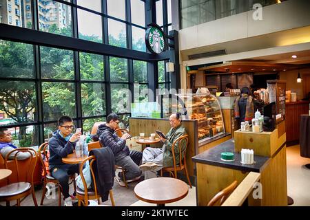 HONGKONG, CHINA - 04. FEBRUAR 2015: Innenausstattung des Starbucks Cafés. Die Starbucks Corporation ist ein amerikanisches globales Kaffeeunternehmen mit Sitz in einer Kaffeekette Stockfoto