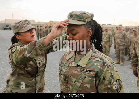 Camp Arifjan, Kuwait. 5.. November 2022. USA Army Staff Sergeant Taysia Brooks, ein ranghöchster Offizier der 369.. Nachhaltigkeits-Brigade, erhält eine neue Patrouillenschutzkappe von 1. Sergeant Rebecca Santana, Headquarters and Headquarters Company 369. Sustainment Brigade First Sergeant, während einer Werbe-Anerkennungszeremonie in Camp Arifjan, Kuwait, November. 4, 2022. Staff Sergeant Brooks wurde aus dem Rang des Sergeant befördert. Kredit: USA Army/ZUMA Press Wire Service/ZUMAPRESS.com/Alamy Live News Stockfoto