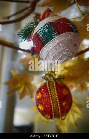 Weihnachtskugel hängt ganz nah am Baum. Stockfoto