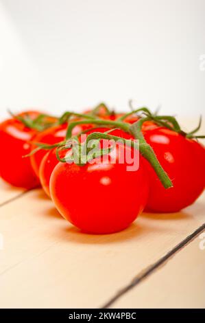 Frische Kirschtomaten auf einem rustikalen Holztisch Stockfoto