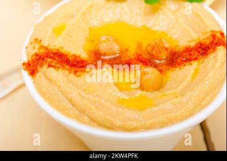 Traditionelle Kichererbsen Hummus mit Minze Olivenöl und Paprika auf der Oberseite Stockfoto