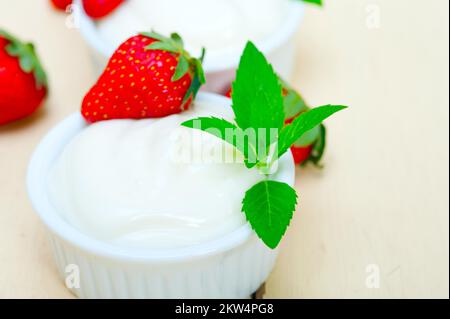 Griechischer Bio-Joghurt und Erdbeere auf dem weißen rustikalen Holztisch Stockfoto