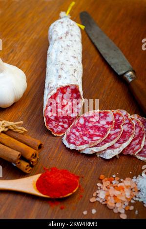 Traditionelle italienische Salami-Wurst, die auf einem Holzbrett geschnitten wurde Stockfoto