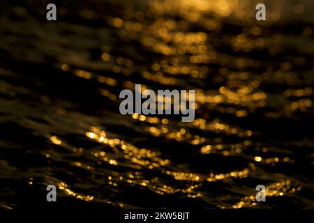 Bokeh-Licht auf schwarzem Hintergrund isoliert. Bokeh-Lichteffekt über Wasser. Stockfoto