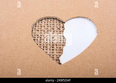 Papier und Leinwand aus Pappe durch ein herzförmiges Loch zu sehen Stockfoto