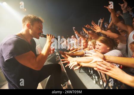 Ich genieße jeden Song der Band. Fans, die ein Musikfestival im Freien genießen. Stockfoto