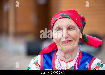 Eine alte weißrussische oder ukrainische Frau in einem bestickten Hemd. Slawische ältere Frau in ethnischer Kleidung. Stockfoto