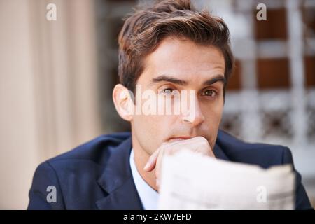 Der beste Makler der Stadt. Porträt eines gutaussehenden Geschäftsmanns, der draußen mit einer Zeitung sitzt. Stockfoto