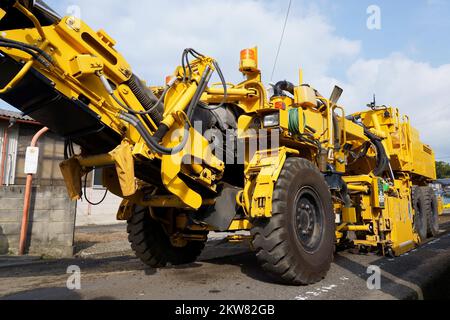 Die Kaltfräsmaschine entfernt den alten Asphalt. Instandsetzung der Fahrbahnoberfläche. Straßenarbeiten. Stockfoto