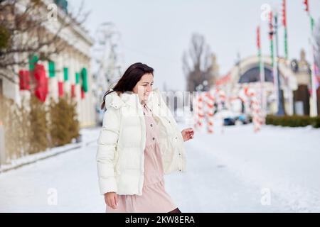 Stylische Frau läuft draußen Skaten. Fröhliche Weihnachten. Träume werden wahr Konzept. Stockfoto