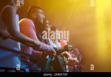 In der Konzertatmosphäre gefangen. Eine Menge bei einem Musikkonzert. Stockfoto