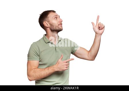 Ein erwachsener Mann im grünen T-Shirt, der nach rechts zeigt, isoliert auf Weiß Stockfoto