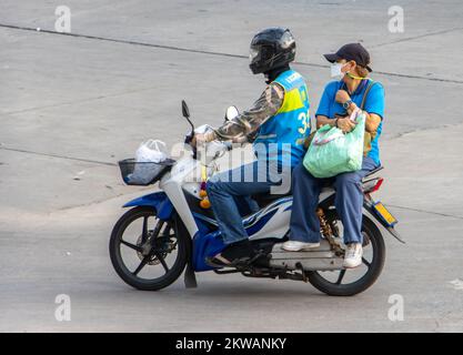SAMUT PRAKAN, THAILAND, MÄRZ 02 2022, Ein Taxifahrer auf einem Motorrad fährt mit einer Frau. Stockfoto