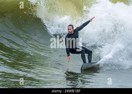 Surfer reiten im Spätherbst in der Nähe des Jacksonville Beach Pier in Jacksonville Beach, Florida. (USA) Stockfoto